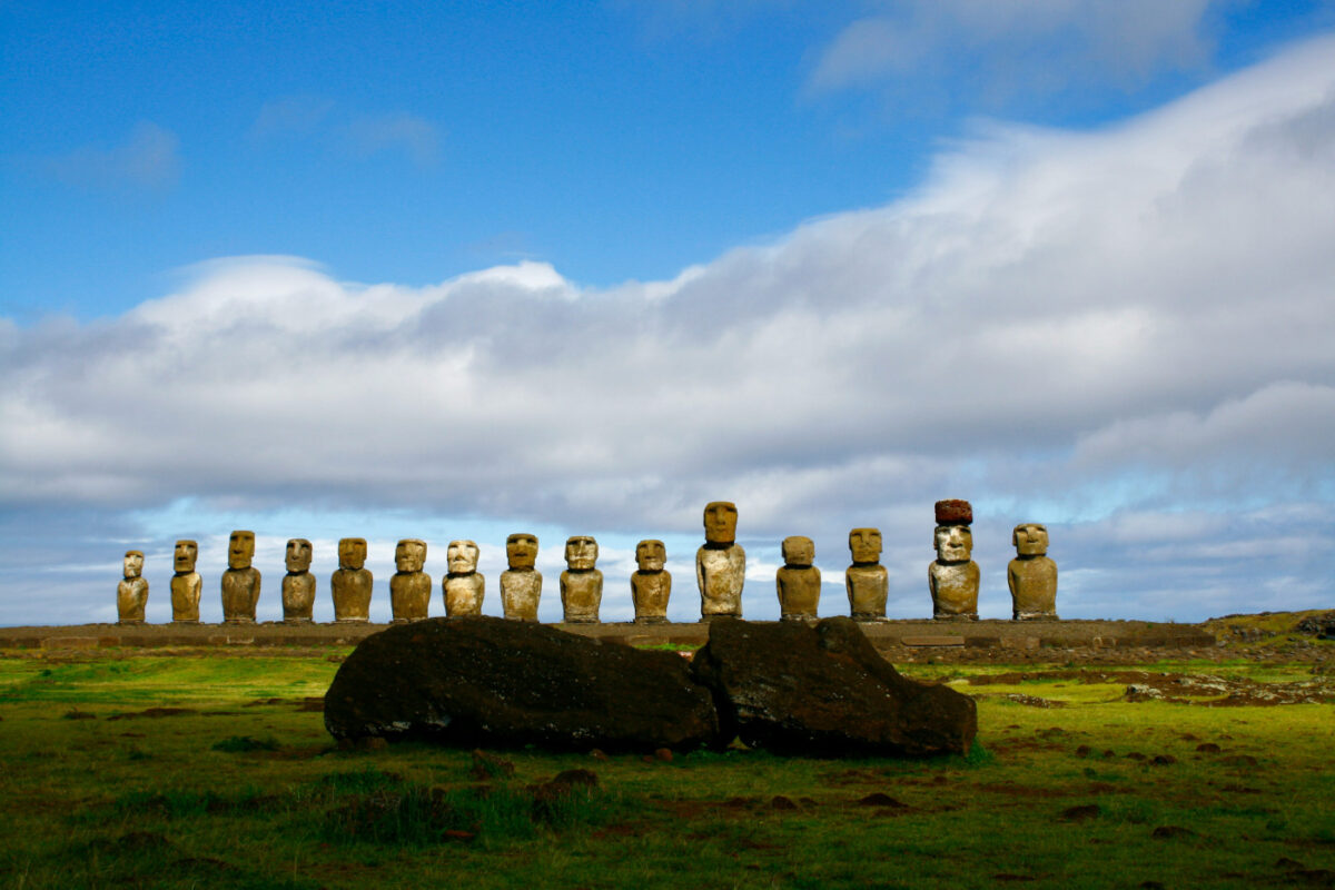 15 Moai sculptures standing on Easter Island. One sculpture is lying in front.